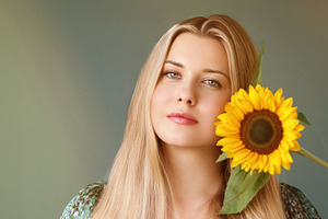 Woman posing with sunflower by face, capturing natural beauty an, a Person Photo by Studio ANNA