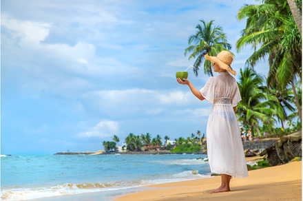 Girl on the beach drinks coconut, a Person Photo by yanadjana