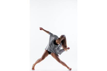 Young beautiful dancer in beige dress dancing on white background stock photo, a Sports & Recreation Photo by Volodymyr Melnyk