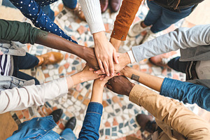 Hands assembling a mosaic of interlocking puzzle pieces, a Person Photo by DanFLCreativo