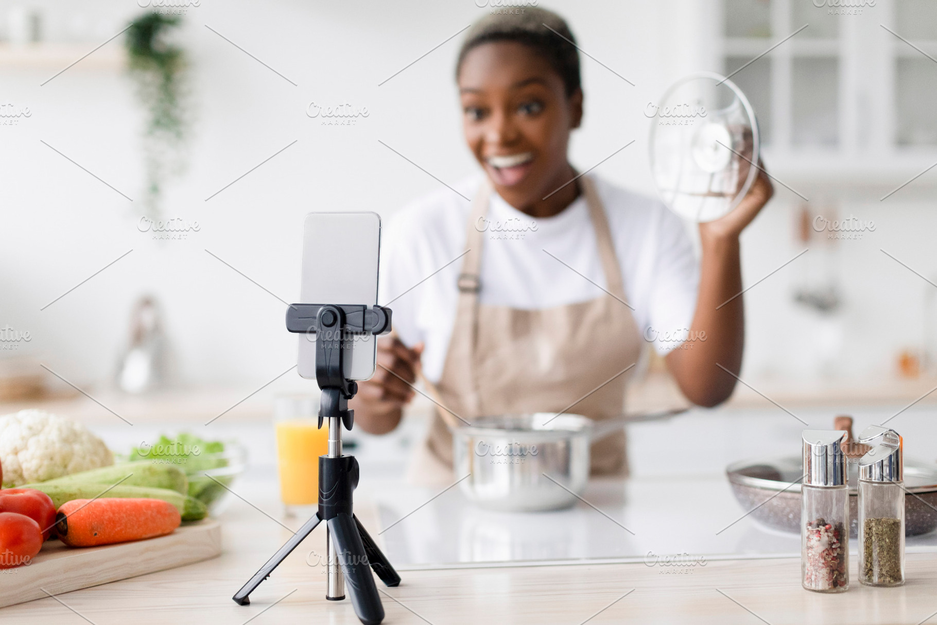 Smiling surprised millennial black female with open mouth in apron prepares lun, a Person Photo by Prostock-Studio
