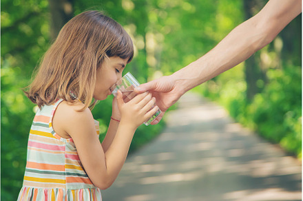 The father gives the child a glass, a Food & Drink Photo by yanadjana
