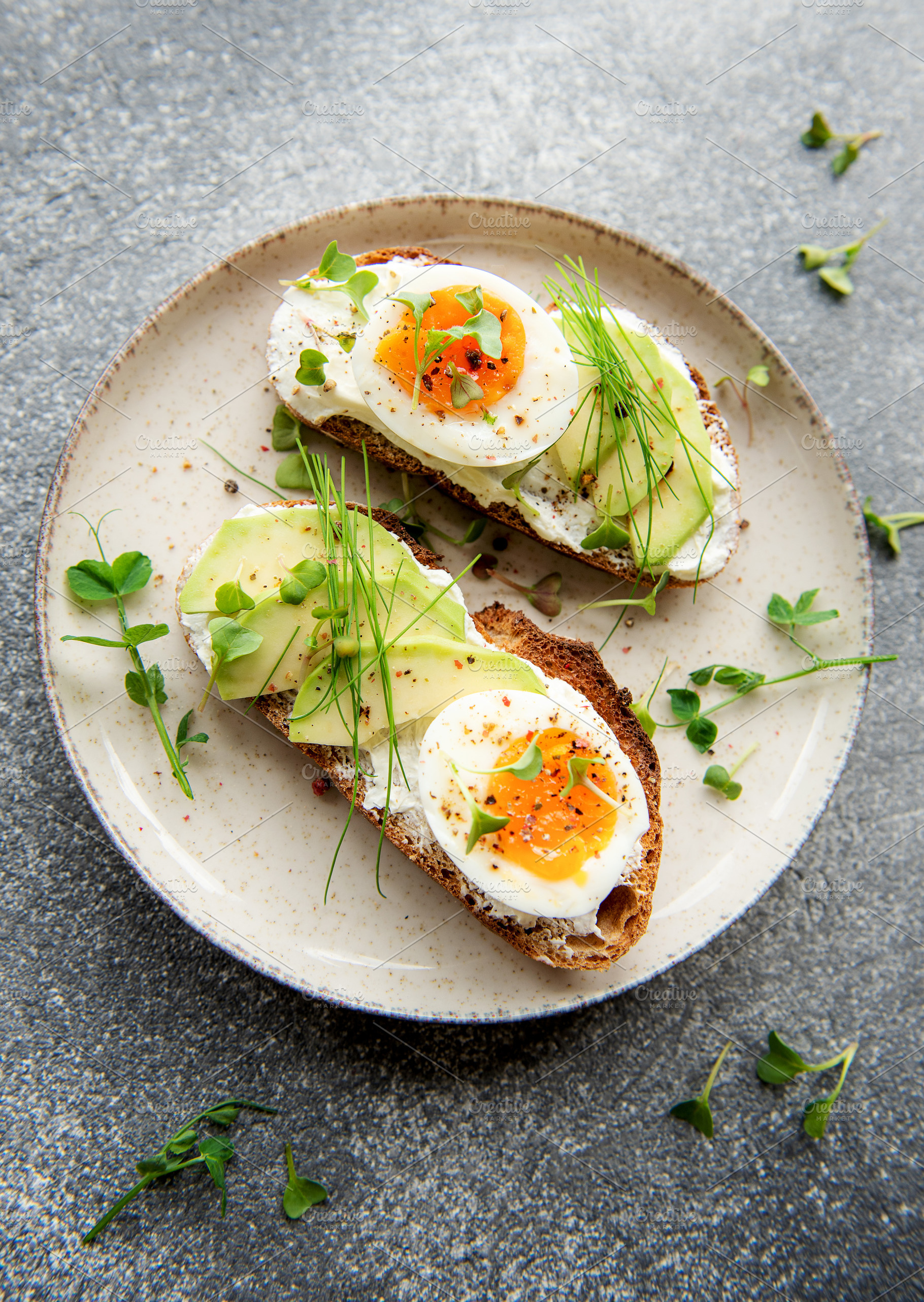 Bread toast, boiled eggs, avocado slice, microgreens on a plate, a Food & Drink Photo by Olena Rudo