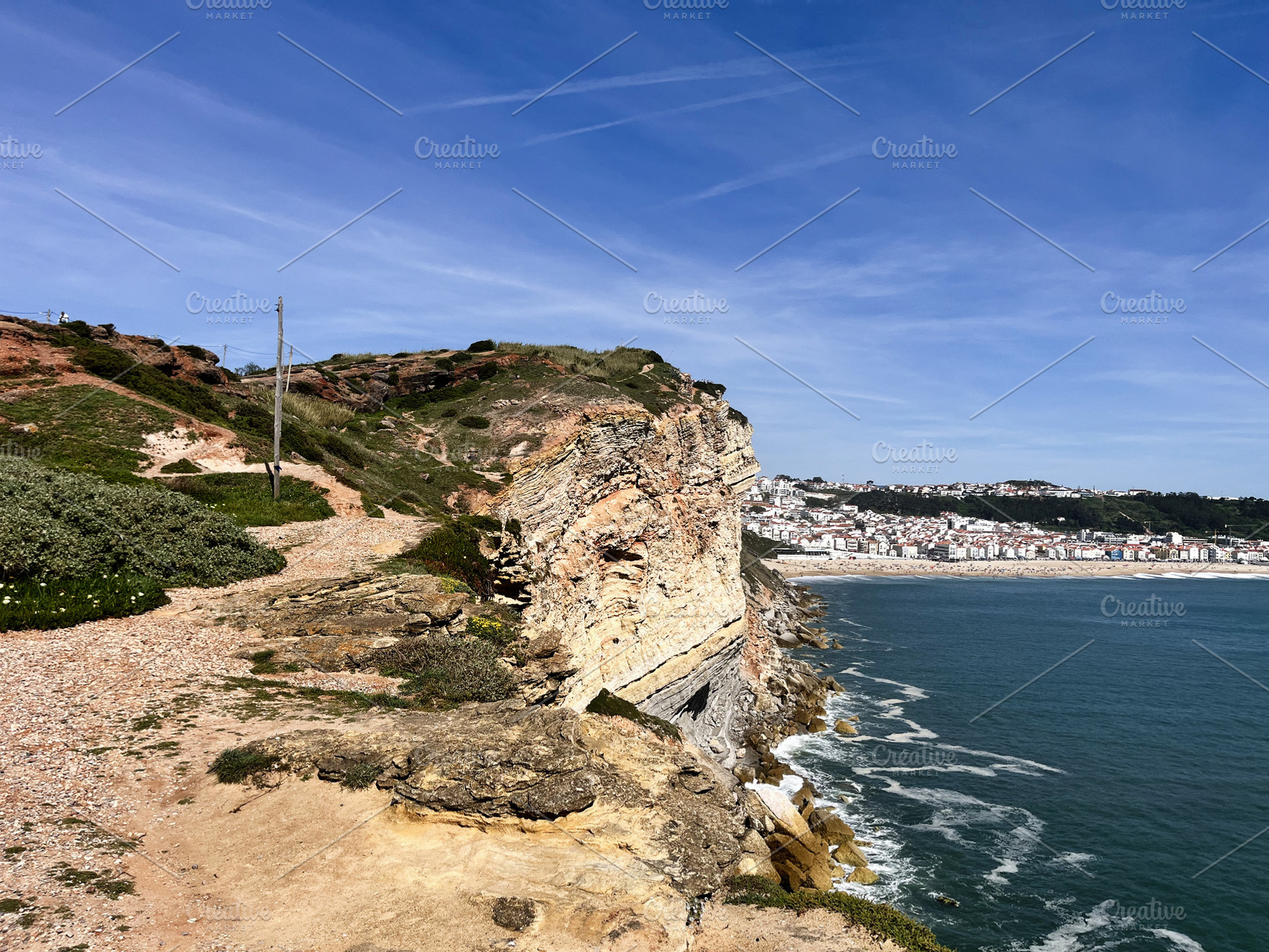 Scenic coastline view in Nazaré, Portugal with cliffs and a distant town, a Photo by AS photostudio