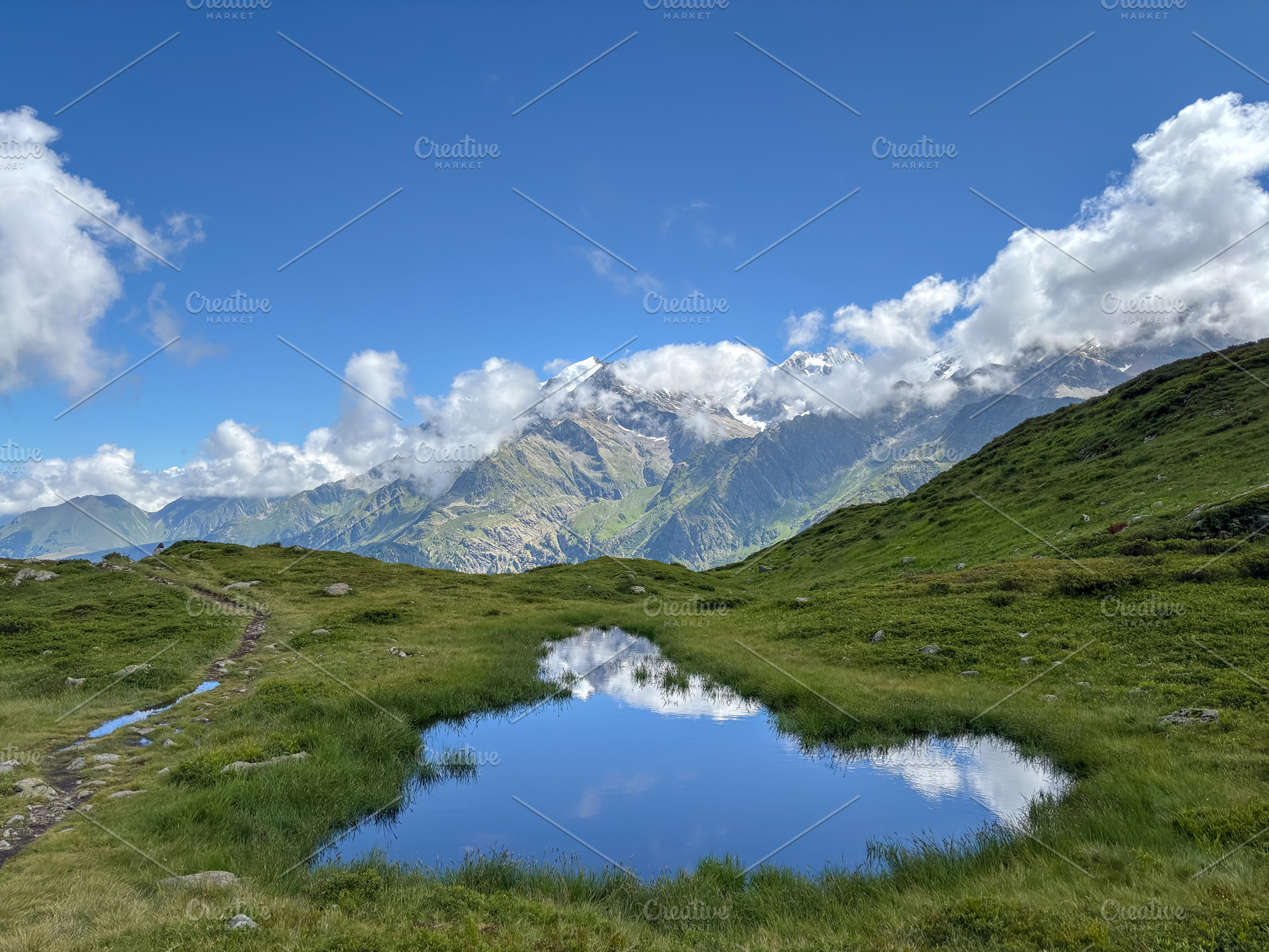 Small alpine pond reflecting Mont Blanc peaks, France, a Nature Photo by GoodGoods