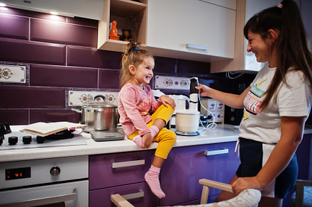 Mother with daughter cooking at kitchen, happy children's moment, a Person Photo by AS photostudio