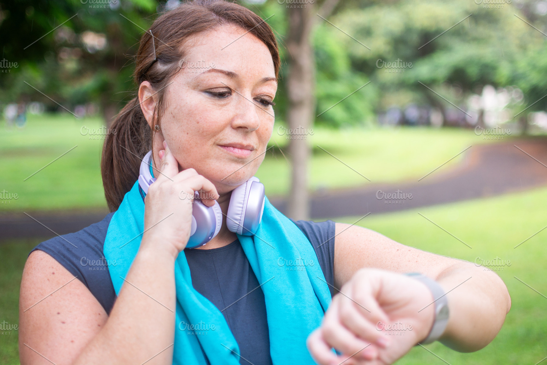 Woman checking her fitness tracker after exercising outdoors, a Photo by etorres69