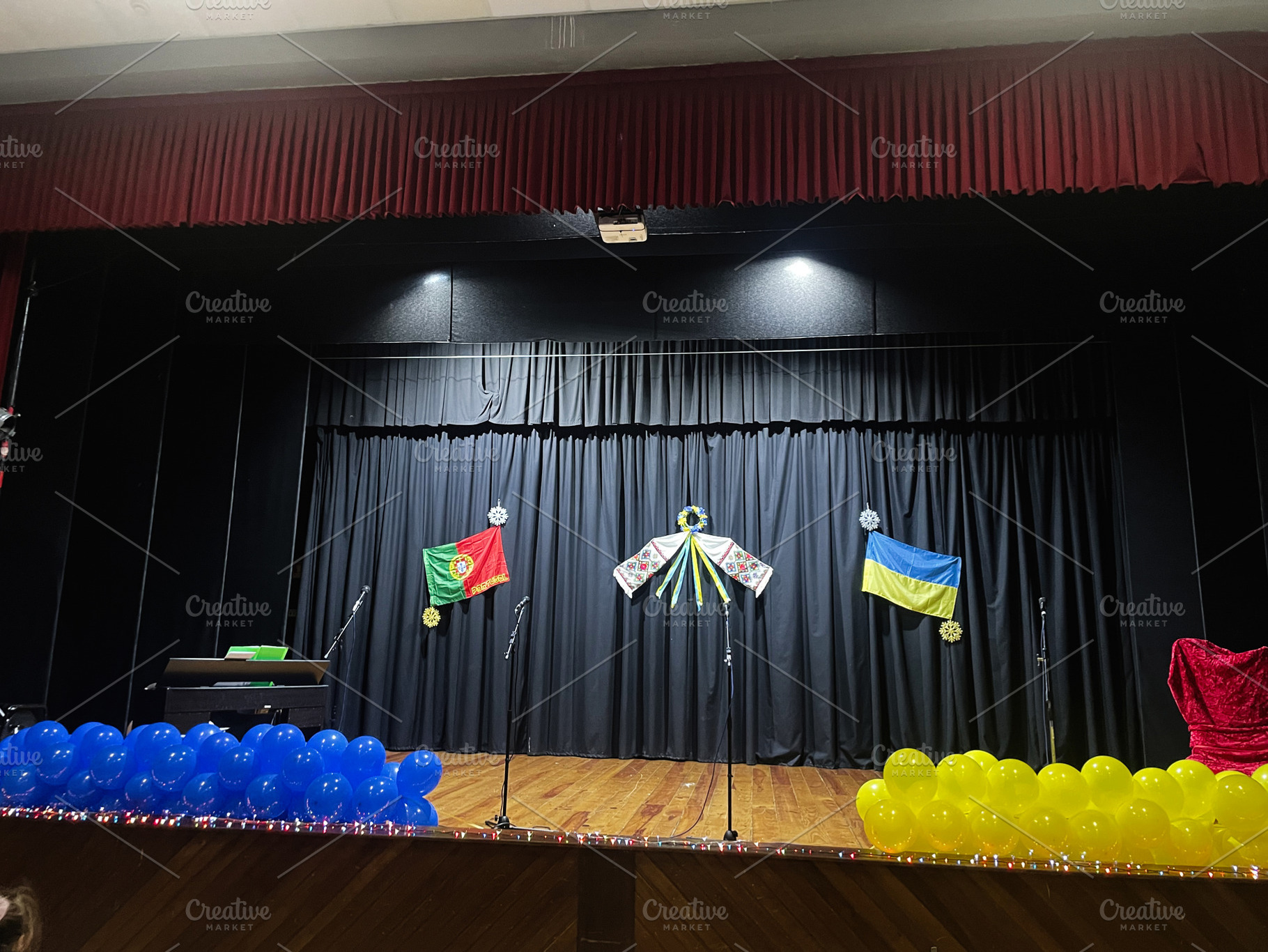 Decorated stage with flags and balloons symbolizing countries at cultural event, a Photo by AS photostudio