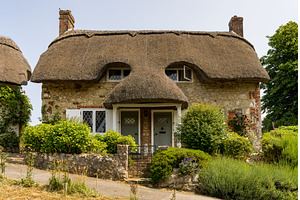 Pair of cute thatched cottages on, an Architecture Photo by Backyard Stock