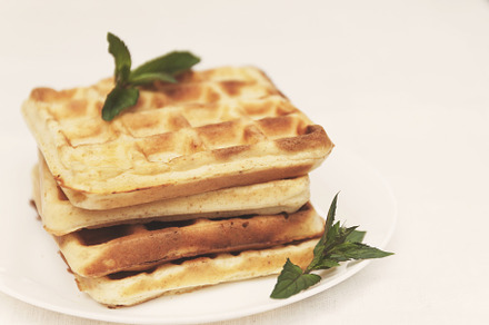 Belgian waffles with fresh mint on a white plate on a white tabl, a Food & Drink Photo by TanaCh