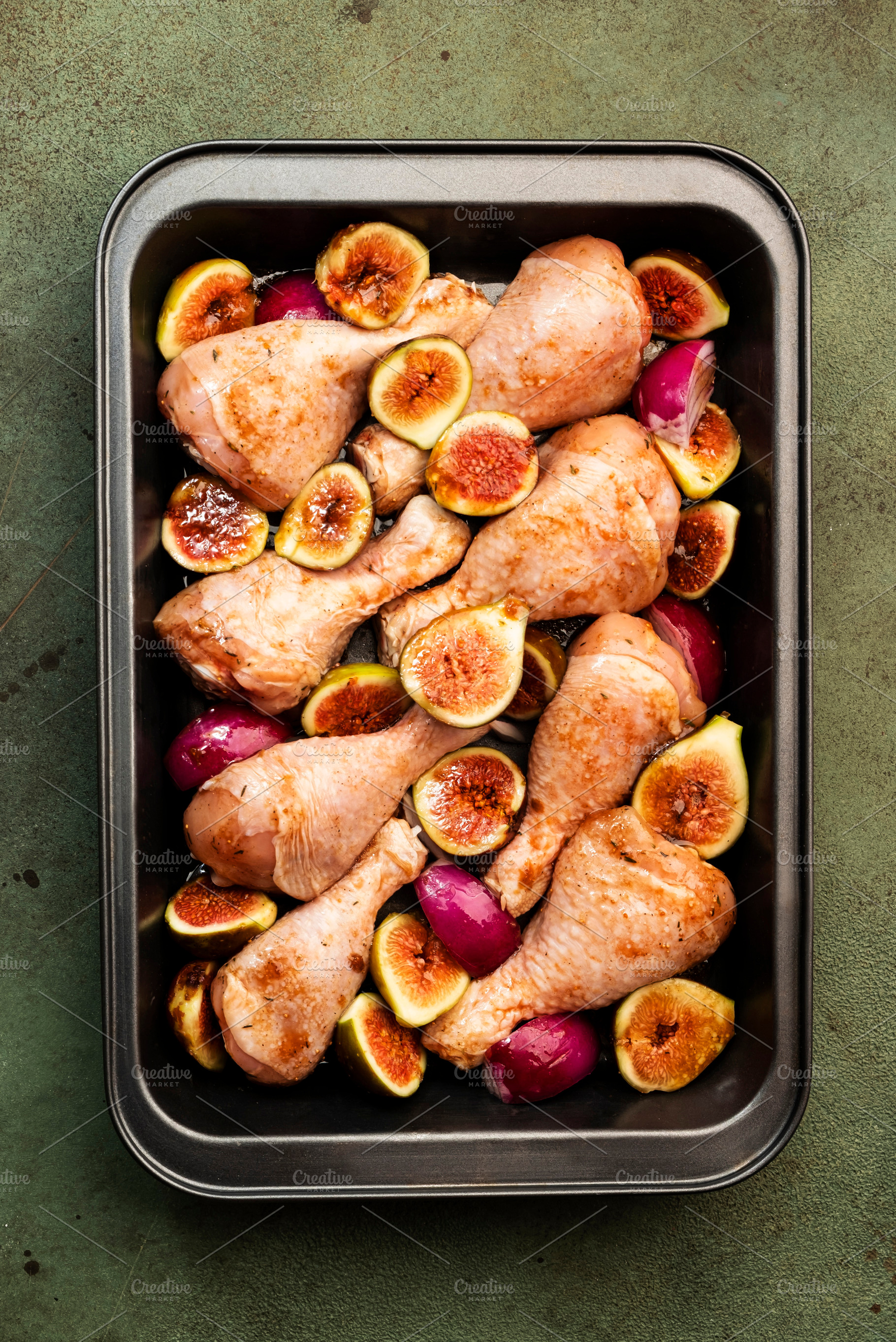 Raw chicken legs, drumsticks with sweet figs and red onions in b, a Food & Drink Photo by 5PH