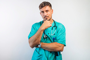 Serious Doctor with Hand on Chin Thinking, a Person Photo by karrastock