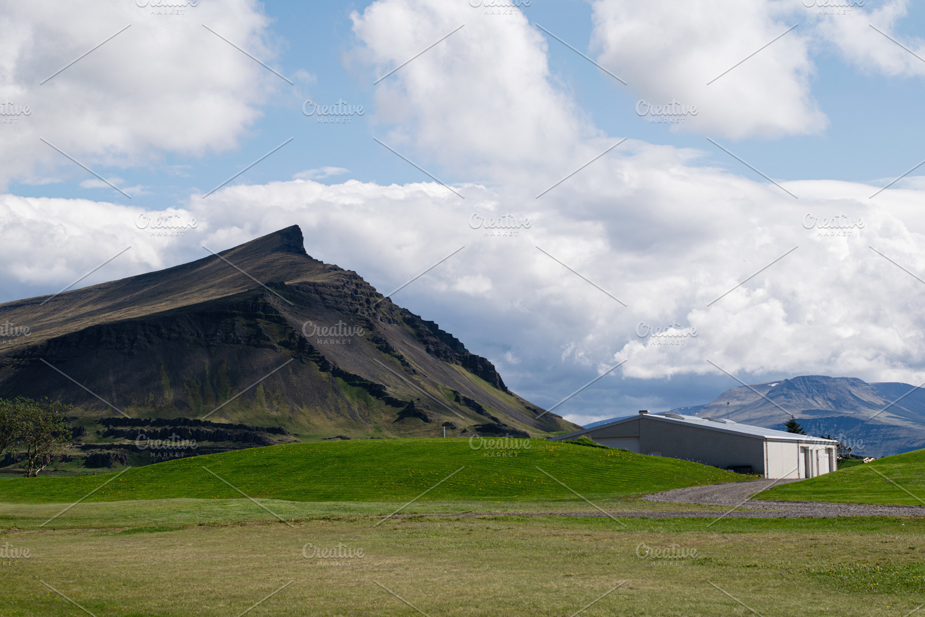 Scenic landscape of Akranes Iceland with mountain peaks and a rural building, a Photo by AS photostudio