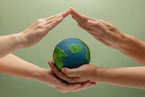 Two people forming a protective roof over Globe. Environmental a, a Photo by salmon.black