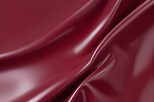 A close-up of deep red glossy leather fabric with soft, flowing folds illuminat, a Background Photo by Kzara Visual Concepts