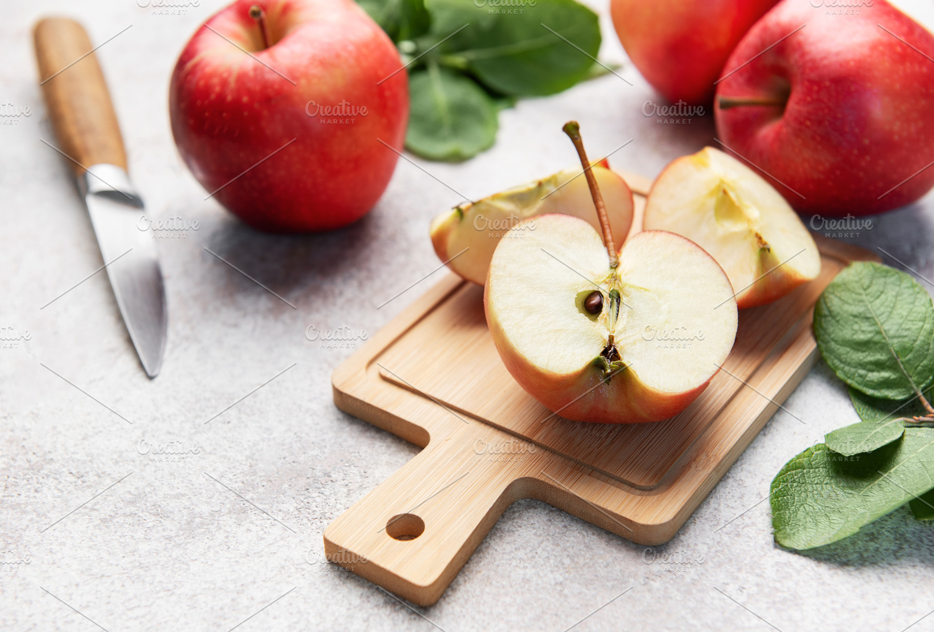 Red apples slicing on cutting board ready for healthy snack, a Food & Drink Photo by Olena Rudo