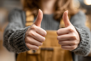 Two thumbs up gesture showing positivity and approval in a casual outfit, a Photo by AS photostudio