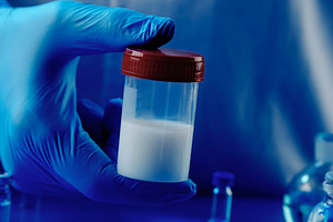 man holding a container with semen, banner, a Photo by Nito