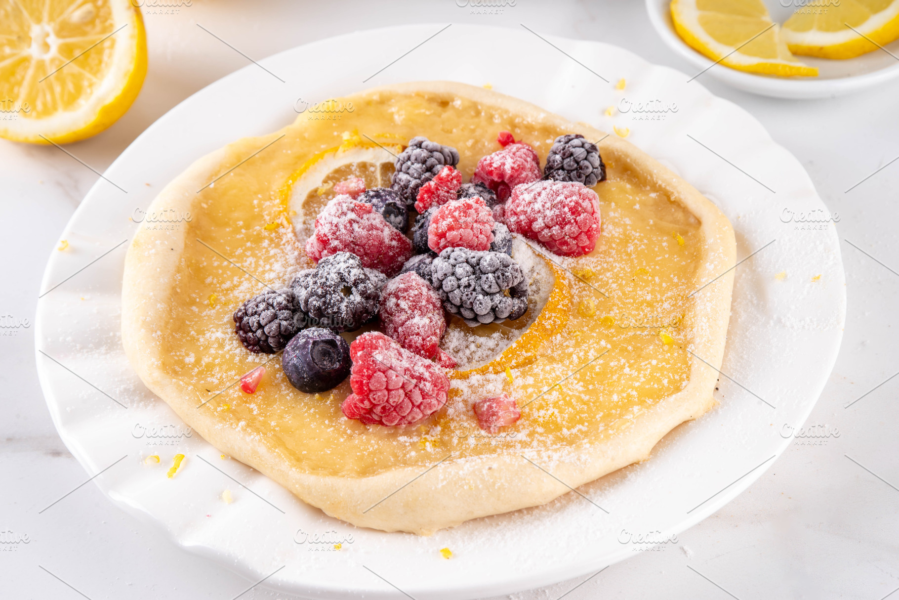 Lemon curd galette cake, with fresh berries, lemon zest and suga, a Food & Drink Photo by Rimma