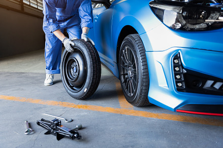 Car mechanics changing tire at auto repair shop garage. Transpor, an Industrial Photo by Ministocker