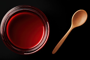 Red liquid in jar with wooden spoon, a Photo by Beautiful things