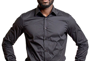 Black man standing in front of a neutral backdrop wearing a bold, a Person Photo by DanFLCreativo