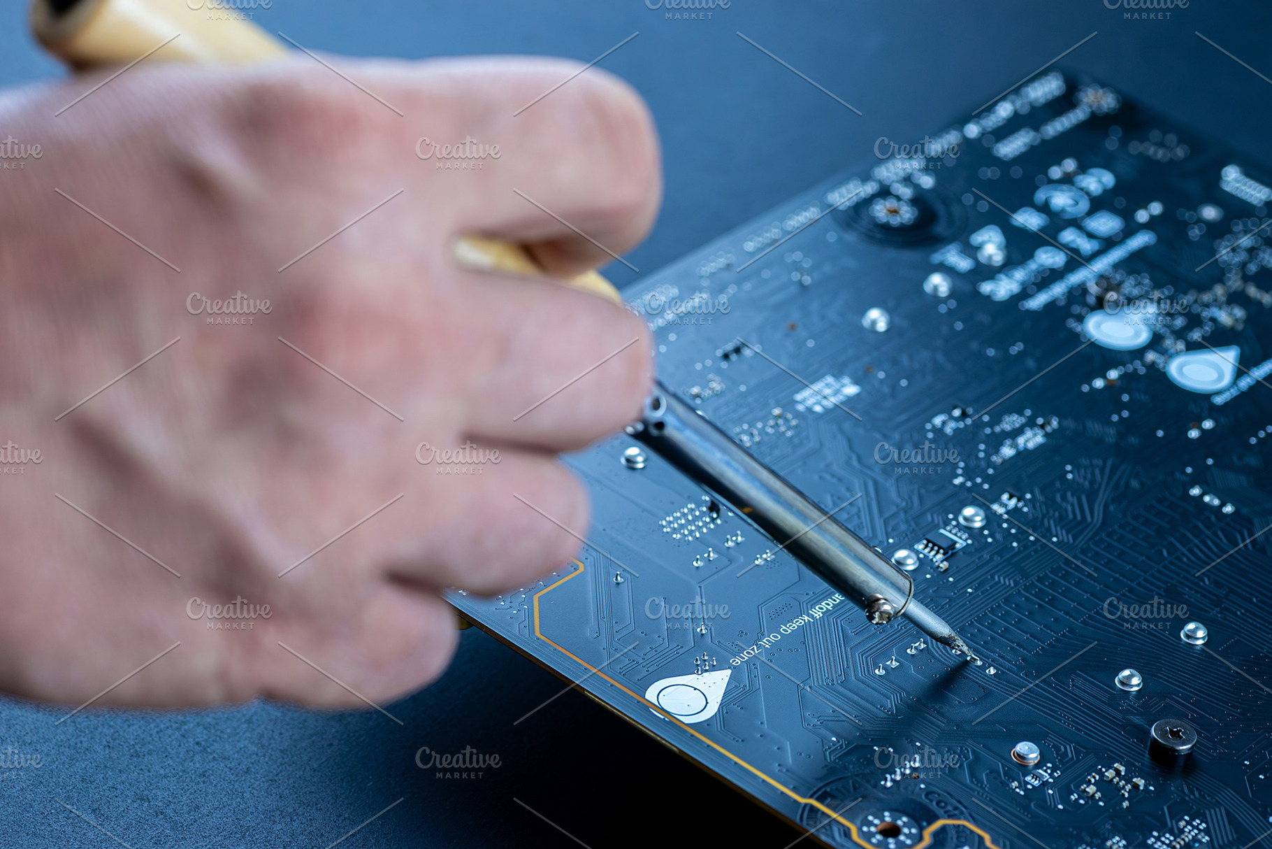 A soldering iron is carefully placed, a Technology Photo by AlexBush