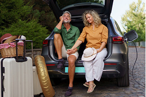 Middle-aged couple sitting in trunk, a Person Photo by HalfPoint