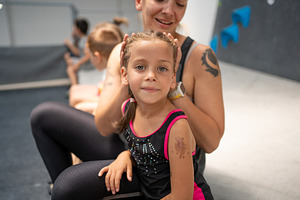 Cute girl sitting with mother on floor at bouldering gym, a Person Photo by andreonegin market