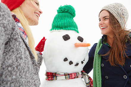 Spending the day making a snowman with her friend, a Photo by Peopleimages.com