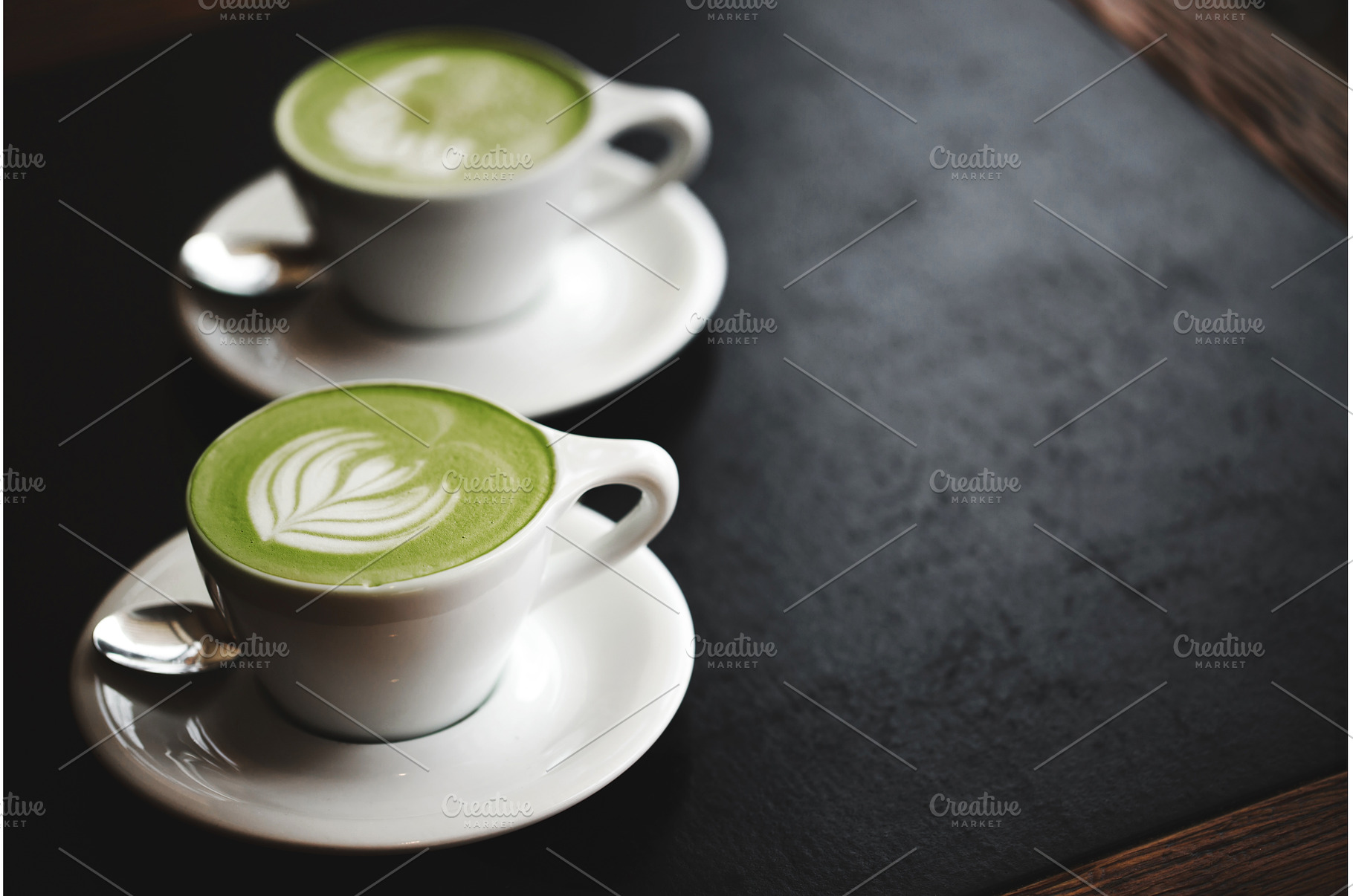 Two cups of matcha latte on black, a Food & Drink Photo by Anna Efetova