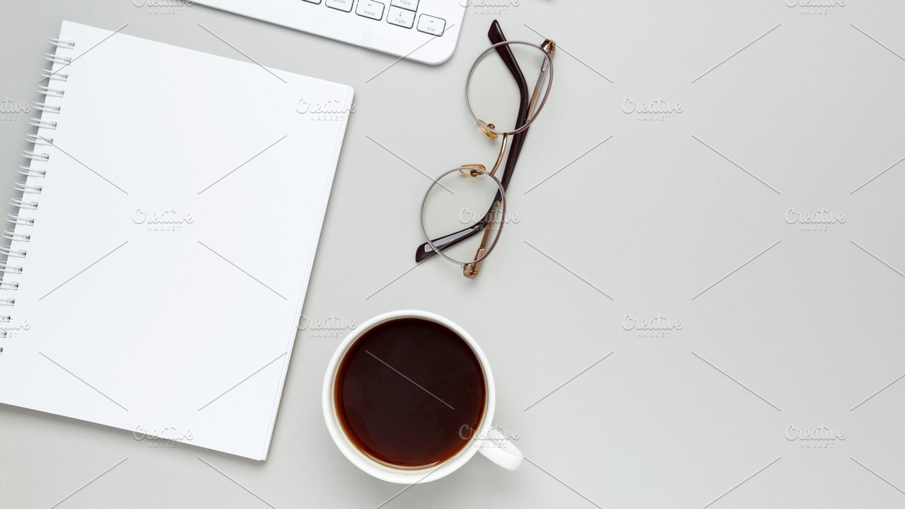 Comfortable workspace setup with coffee cup, keyboard, glasses and notebook sha, a Photo by matucha