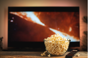 A glass bowl of popcorn and remote, a Technology Photo by Budarinphoto
