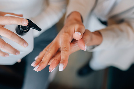 Female hands applying antibacterial liquid soap close up.