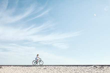 Girl enjoying bike ride under sky containing activity, baskets, and beach, a Transportation Photo by Sergey Furtaev