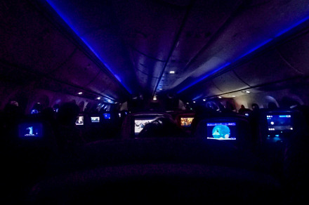 Interior of airplane cabin with personal screens on seats, a Transportation Photo by DanFLCreativo