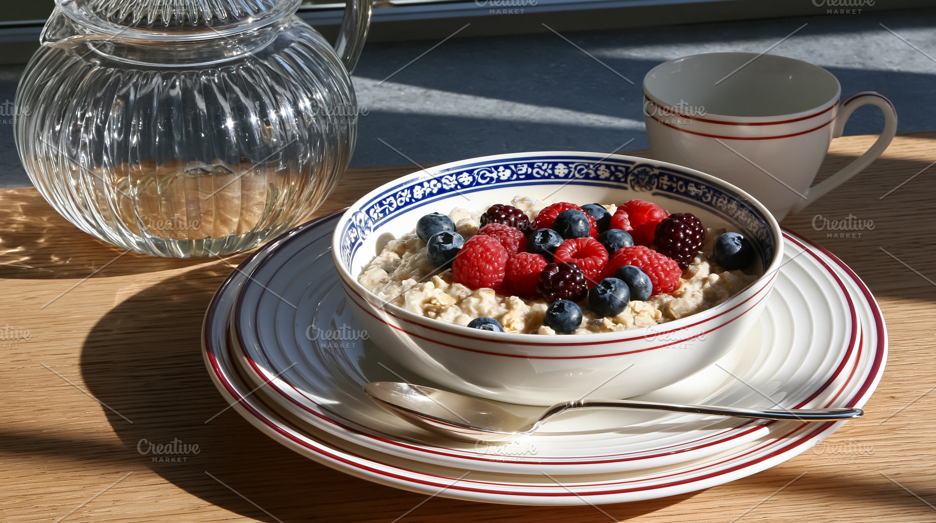Bowl of warm oatmeal porridge topped with fresh mixed berries on a wooden table, a Photo by Studio ANNA