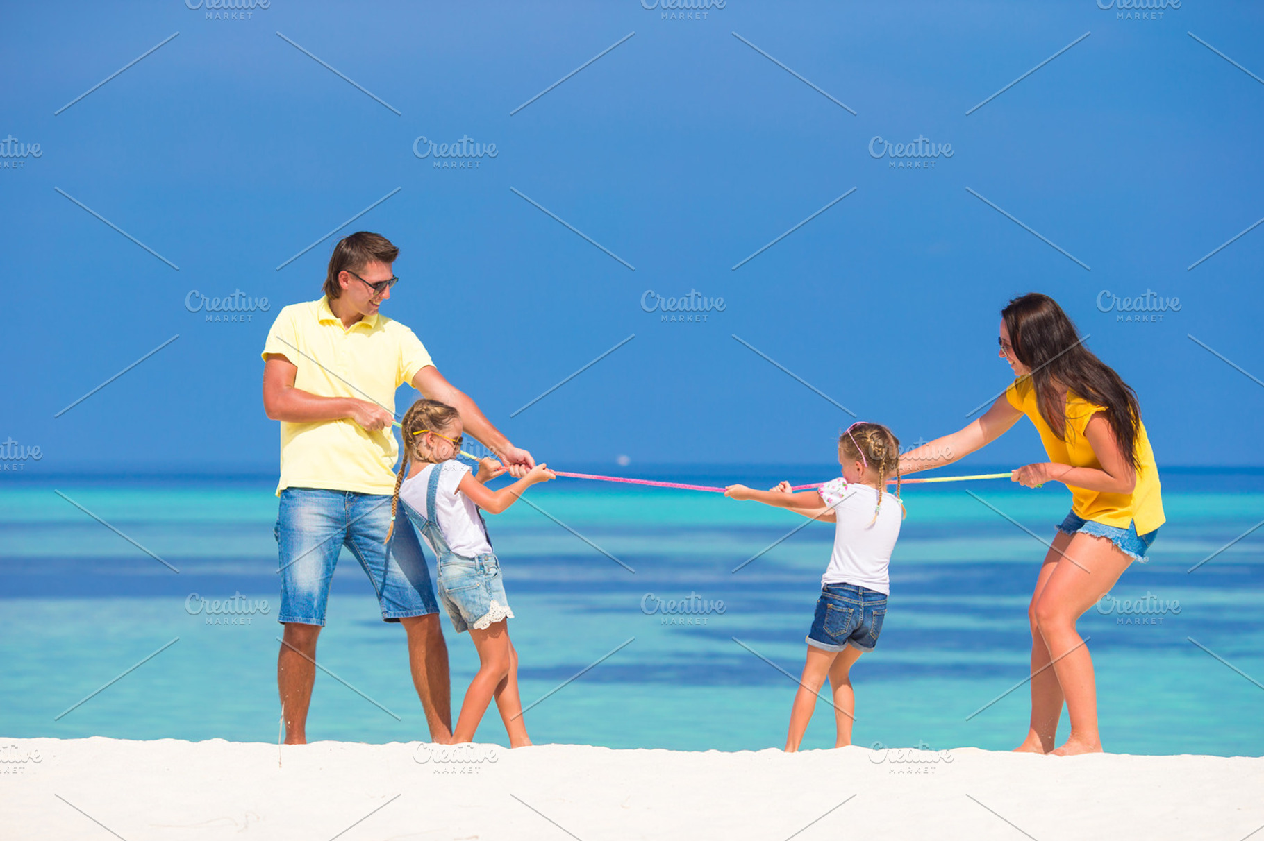 Happy family having fun on white beach stock photo containing adult and beach, a Person Photo by travnikovstudio
