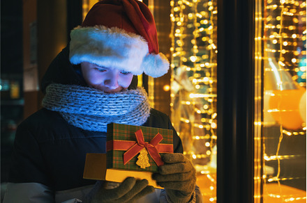 Boy in Santas hat with gifts box, a Person Photo by Jan Jack Russo Media