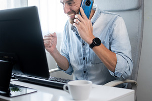 Excited Man Talking on Smartphone While Working at Home Office, a Person Photo by etorres69
