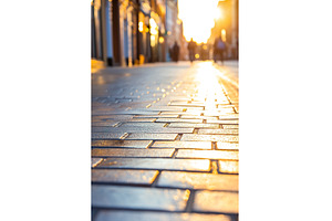 Sunlit urban street with blurred, an Architecture Photo by Lermont51