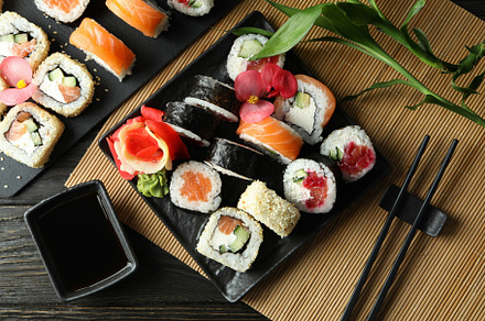 Concept of tasty food with sushi rolls on wooden background, a Food & Drink Photo by AtlasStudio