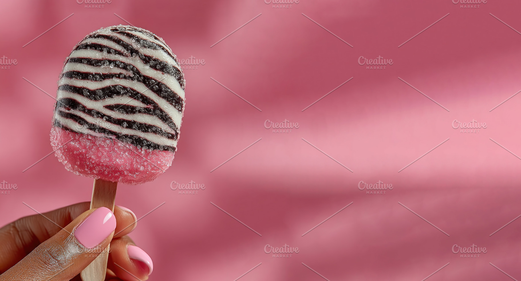 Zebra-striped pink popsicle with frosty texture held by a hand w, a Photo by José Manuel Gelpi