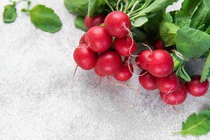 Fresh organic radishes with green leaves on concrete background, a Food & Drink Photo by Olena Rudo