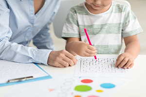 Logical kids development. Close up of little boy exercising with professional t, a Photo by Prostock-Studio