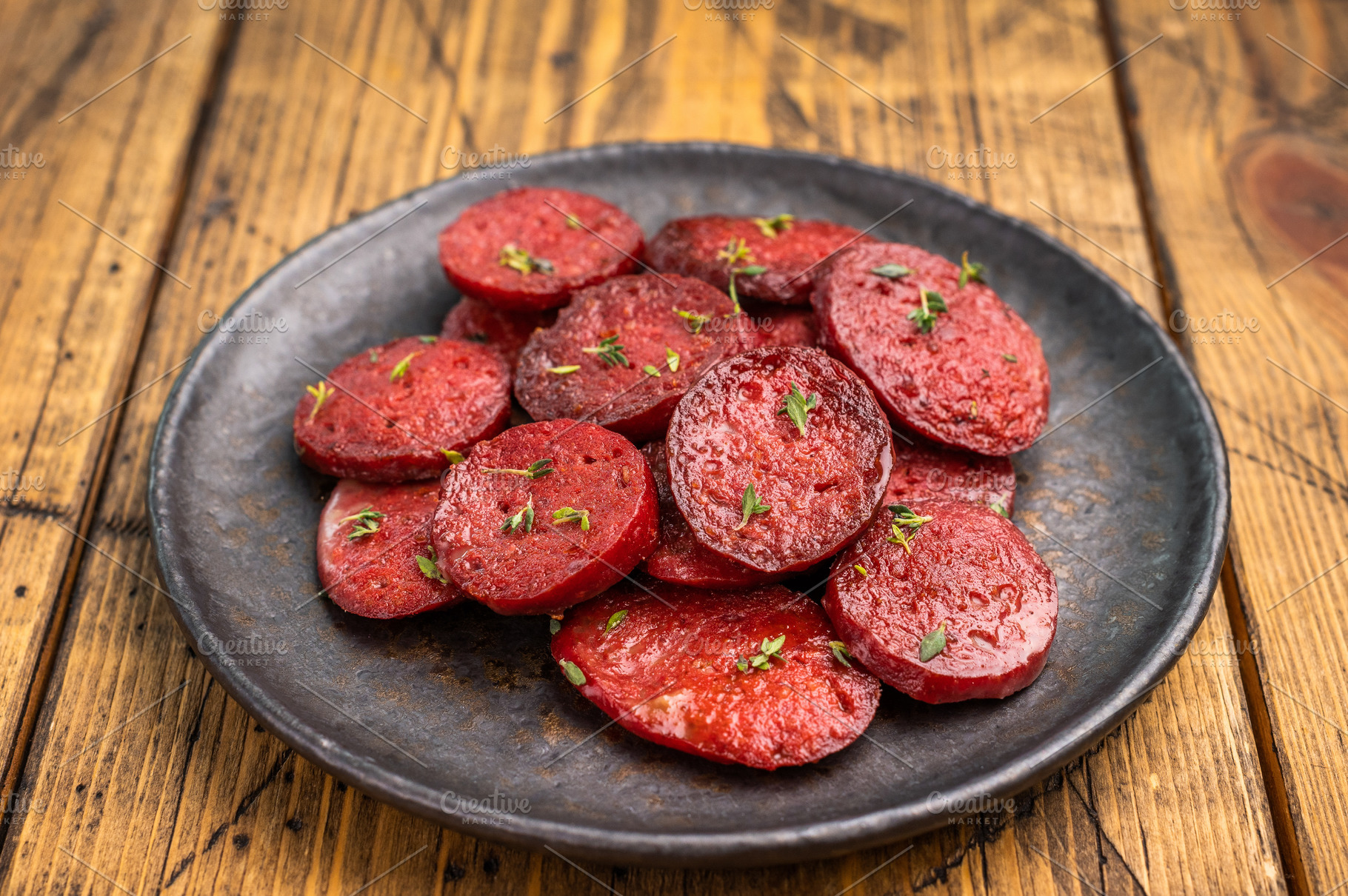 Pan-fried Turkish sucuk (sujuk) slices garnished with thyme on a, a Photo by composter-box@mail.ru