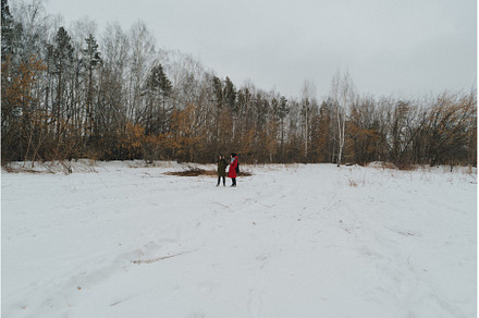 Two individuals stroll across a vast