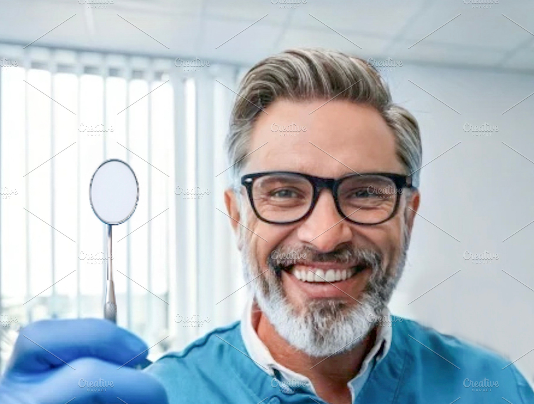 Smiling dentist holding dental mirror, a Health & Medical Photo by DanFLCreativo