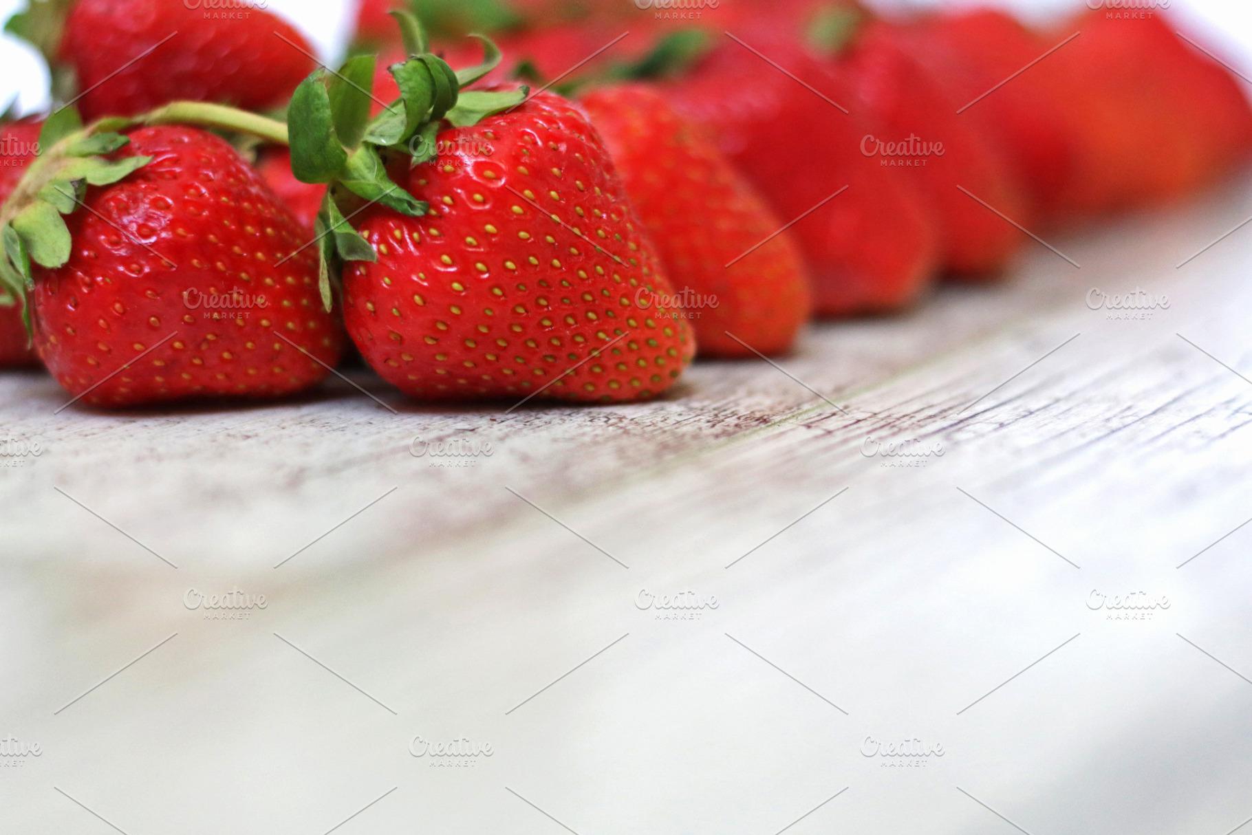 Strawberries on a gray wooden back, a Food & Drink Photo by Iryna Sotnykova