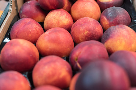a bunch of nectarines in a fruit stand, a Food & Drink Photo by YossSabalet